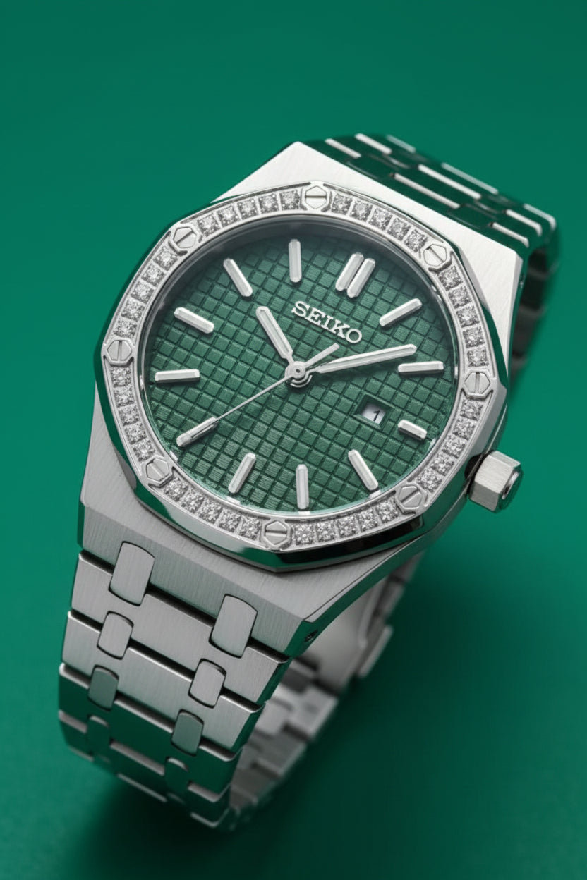 A Seiko stainless steel watch with an octagonal bezel set with clear stones and a textured green dial, shown close-up on a white textured surface.