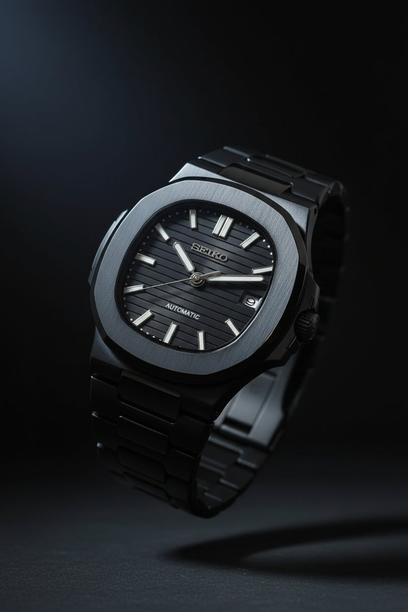 Black watch with metallic band held in a hand against a blurred background