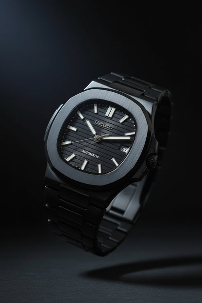 Black watch with metallic band held in a hand against a blurred background