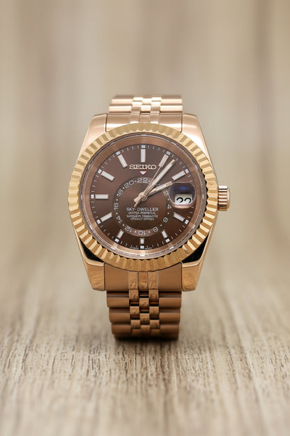 gold Seiko watch with a brown dial on a white background