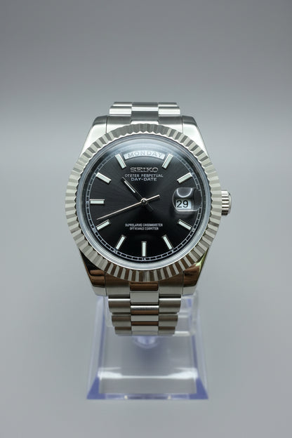 Silver watch with a black face on a dark gray background