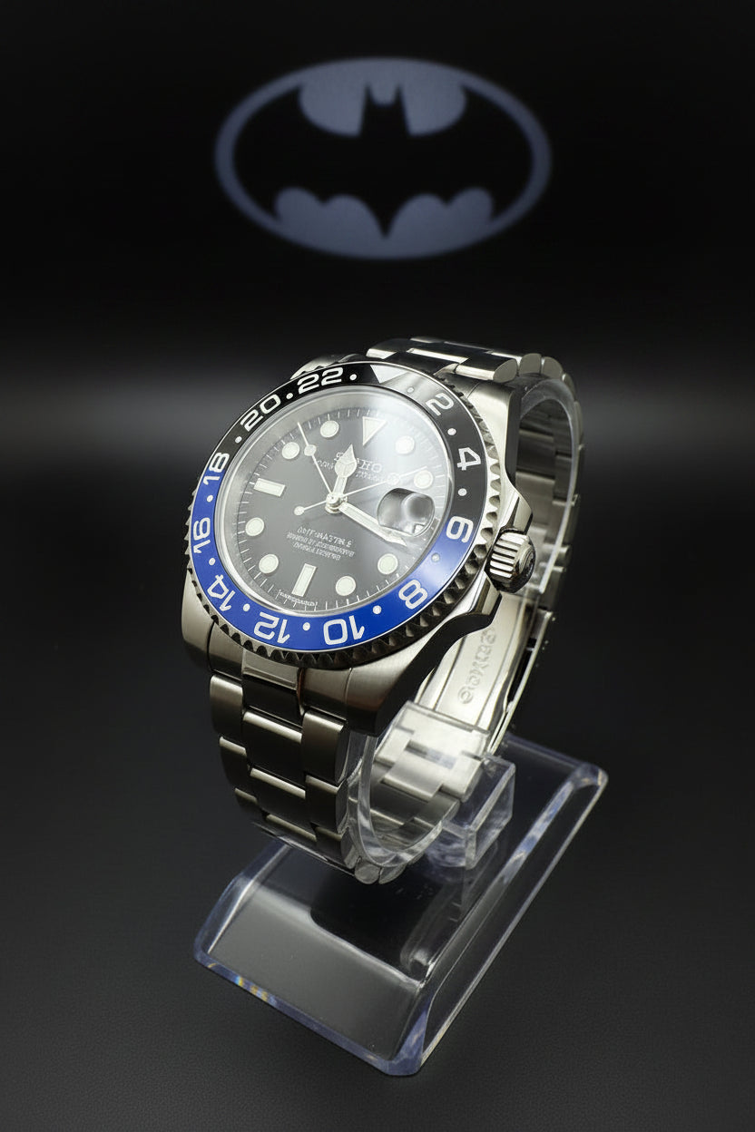 Silver watch with black and blue bezel on a dark background