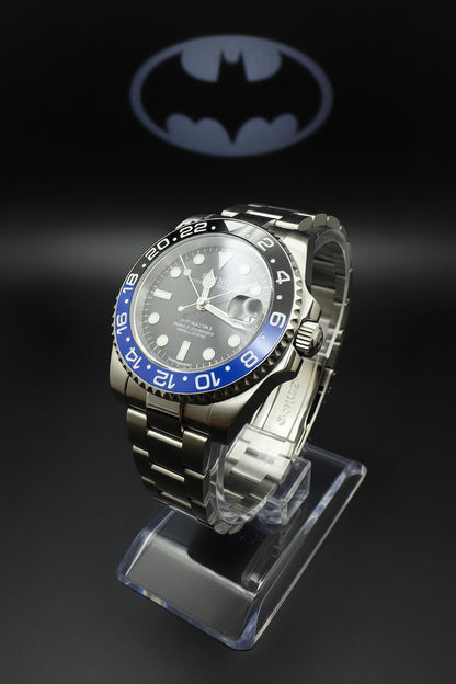 Silver watch with black and blue bezel on a dark background