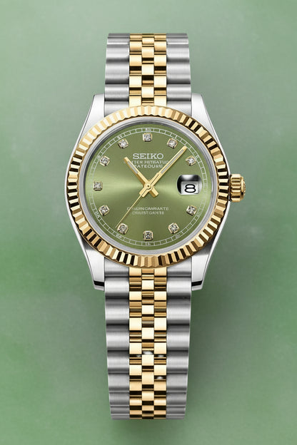 A Seiko two-tone wristwatch with a silver and gold-tone metal bracelet, a fluted gold-tone bezel, and a green dial with diamond hour markers.