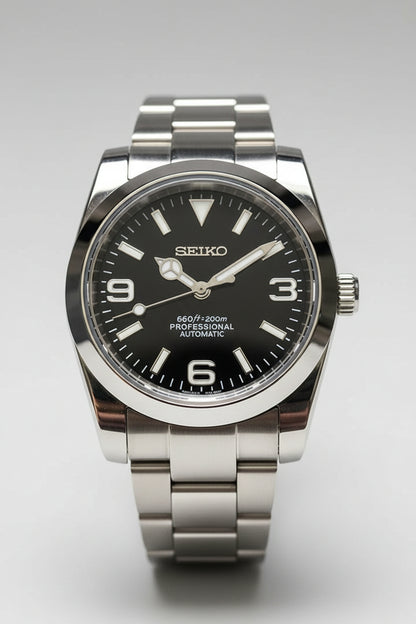 Silver Seiko watch with black dial on a blue fabric background