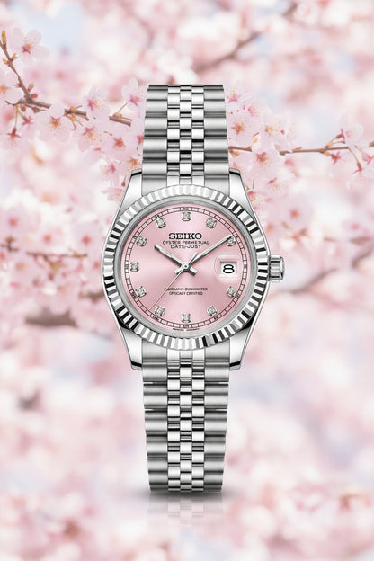 A Seiko women's watch featuring a silver-tone stainless steel Jubilee bracelet and a pink dial with diamond hour markers, shown against a plain white background.