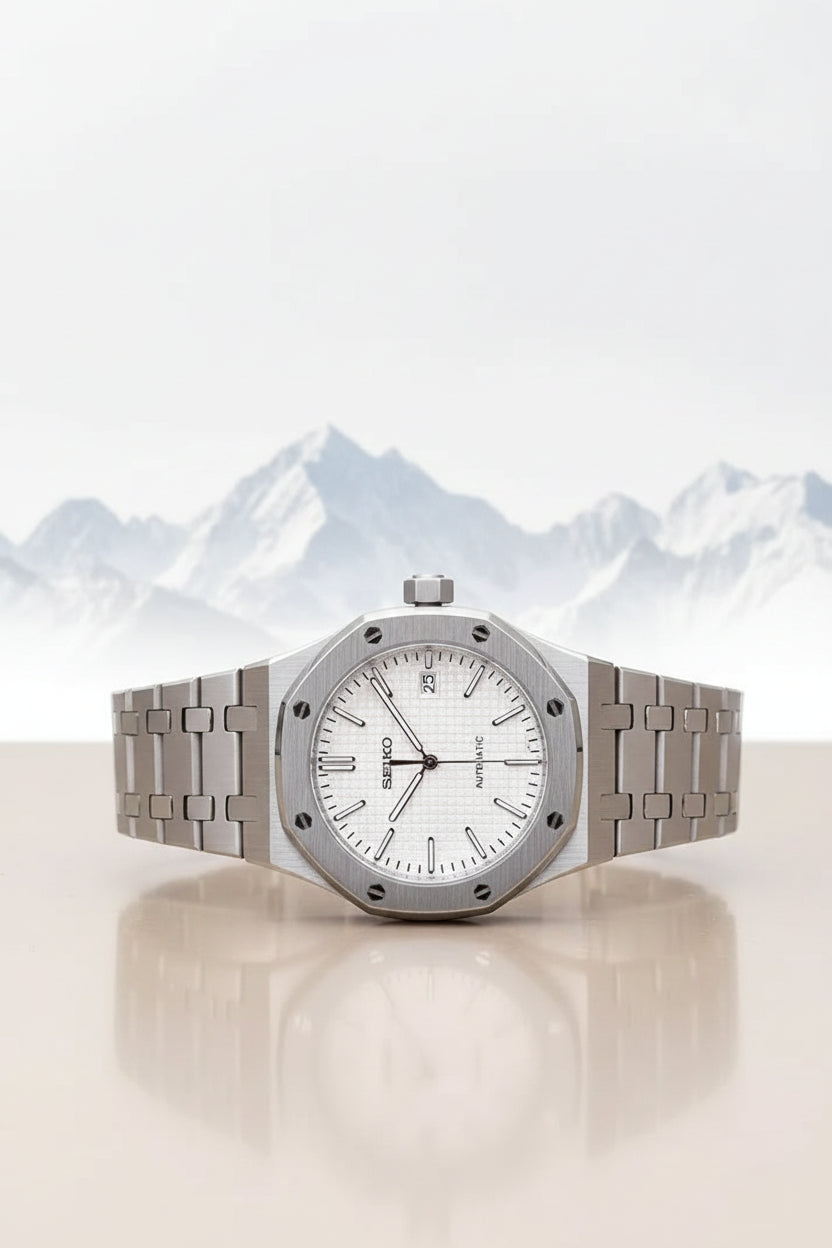Silver watch with a white face on a black strap against a green background