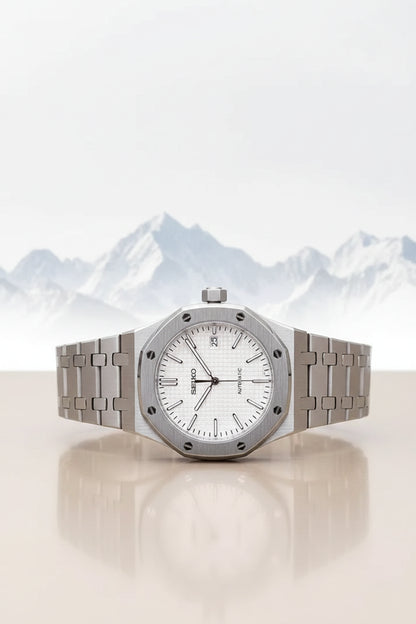 Silver watch with a white face on a black strap against a green background